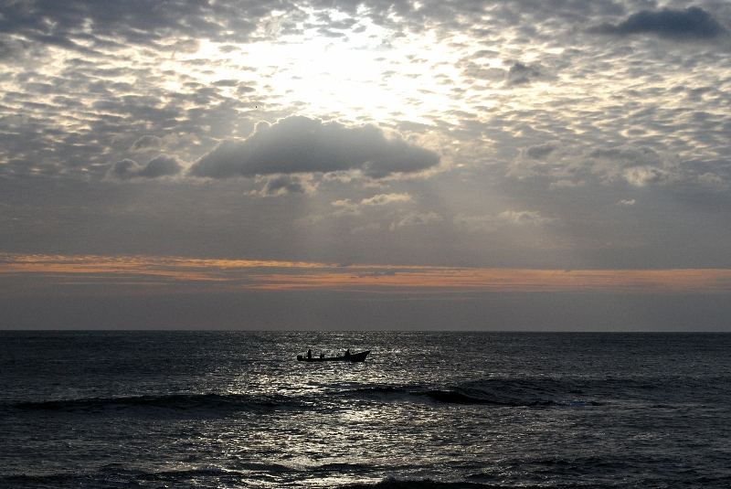 Pescadores arriesgando sus vídas bajo la hermosura de la puesta de sol y sobre la inmensidad del océano. Playa de Casares, Carazo, Nicaragua.