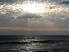 Pescadores arriesgando sus vídas bajo la hermosura de la puesta de sol y sobre la inmensidad del océano. Playa de Casares, Carazo, Nicaragua.